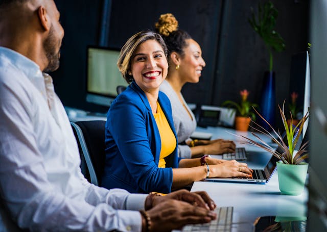 a diverse group of people are smiling at a conference table